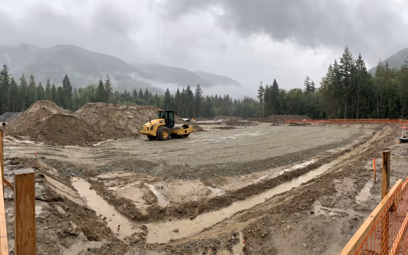 Site preparation earthwork with a compactor and graded base on a British Columbia construction site